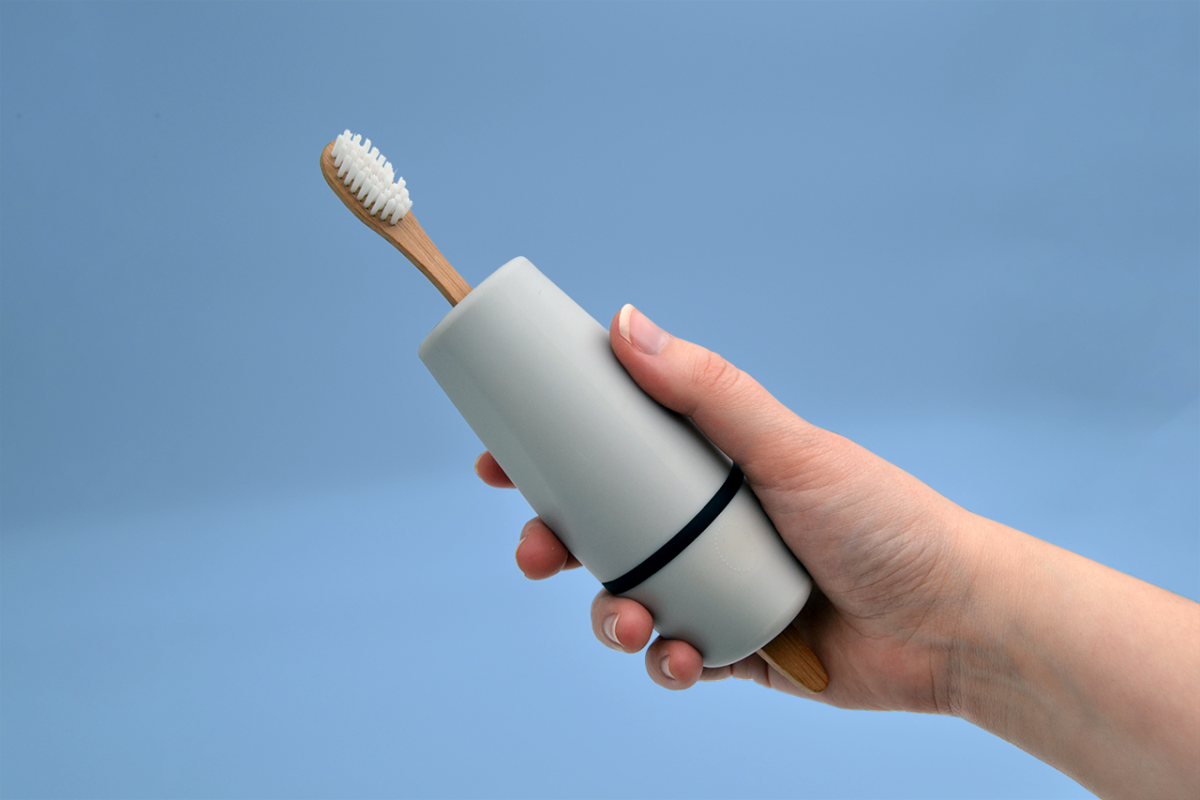 Hånd holder produkt med tandbørste