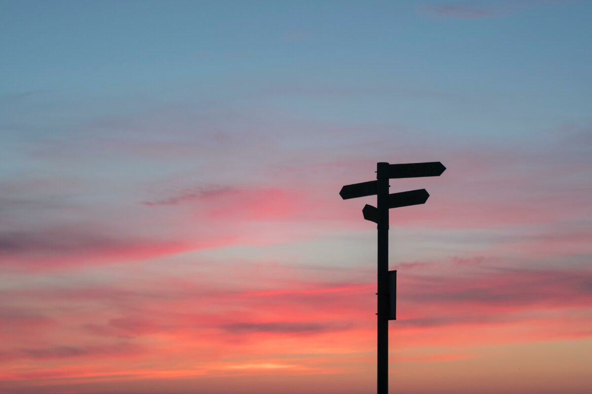 Solnedgang, himmel, skilt der peger i mange retninger